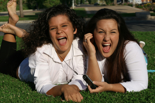 2 girls laughing while listening to music