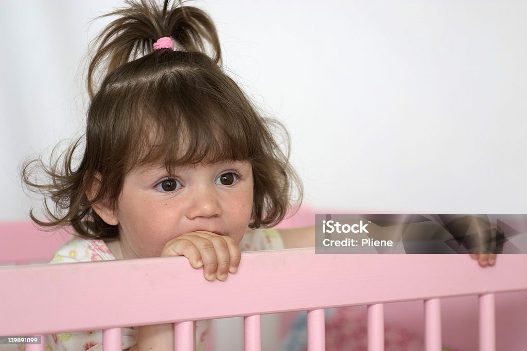 Kid in Bed Little girl standing in her pink bed. Bed - Furniture Stock Photo