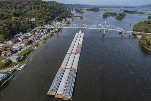 Towboat pushing barges south on the Mississippi River passes under the Blackhawk Bridge at Lansing Iowa.