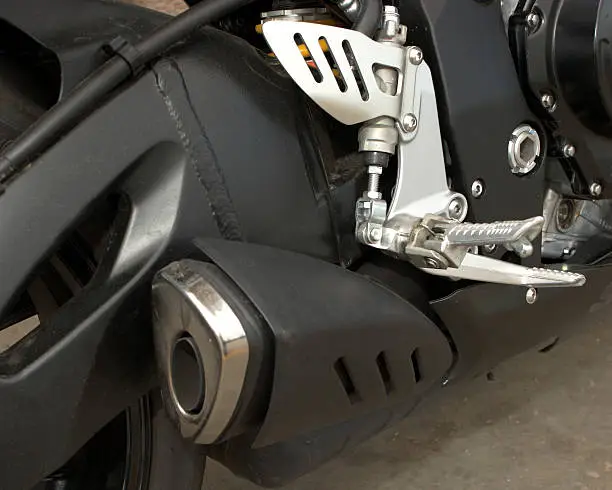 Motorcycle exhaust and footpeg detail.