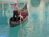 A gondolier on a gondola in the water