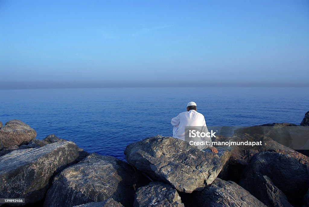 Sea view a man sitting on roeck near sea Adult Stock Photo