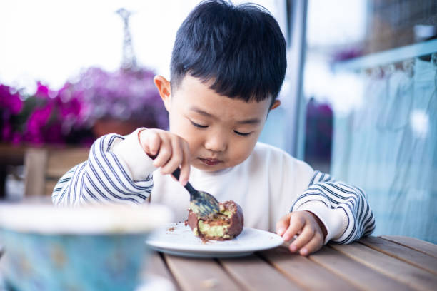 istock Little boy eating a cake at restaurant 1398927210