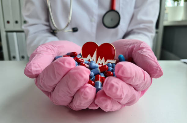 istock Doctor hands with red heart and pills closeup 1398932880