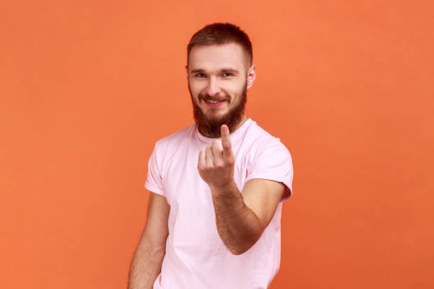 istock Man calling you with finger, looking at camera with playful expression flirting and inviting on date 1398934040