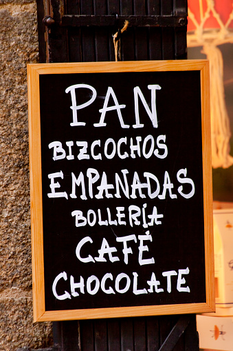 Cafeteria menu chalk  handwriting on blackboard in spanish language. Coffees, chocolate,bread, sponge cake,  sweet bakery items. Seen in the street, Santiago de Compostela, Galicia, Spain.