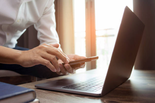 istock Businessman hand using laptop and smart phone working at home office. 1398938966