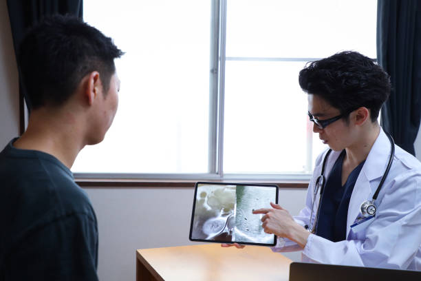 istock Asian male doctor conducting a physical exam 1398938981