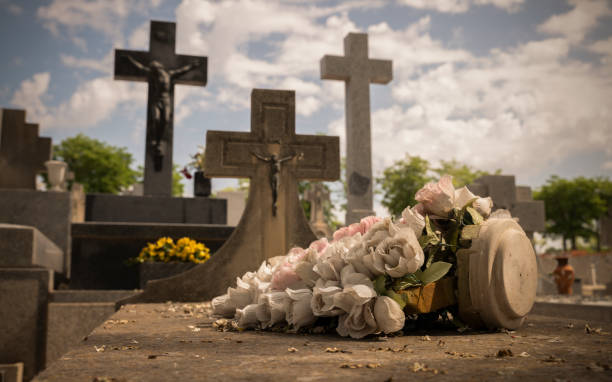 istock Plastic flowers on tomb in cemetery 1398940008