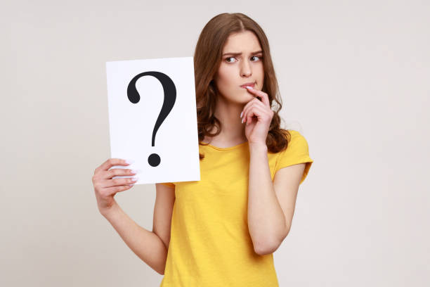 young pensive woman in casual style attire holding paper with question mark over, thoughtful, face thinking about question, very confused idea. - pensive question mark teenager adversity imagens e fotografias de stock