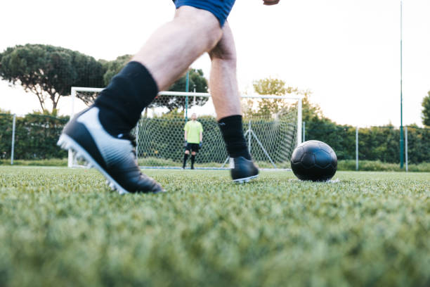 joueur de football sur le point de frapper un penalty - penalty shot photos et images de collection