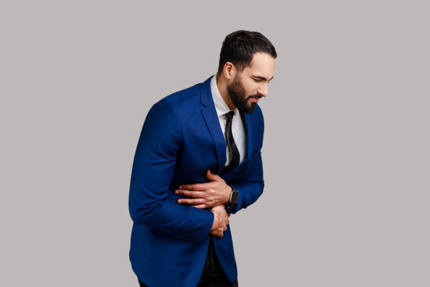 istock Man touching belly, grimacing from stomach ache, severe abdominal distress, symptoms of constipation 1398942741