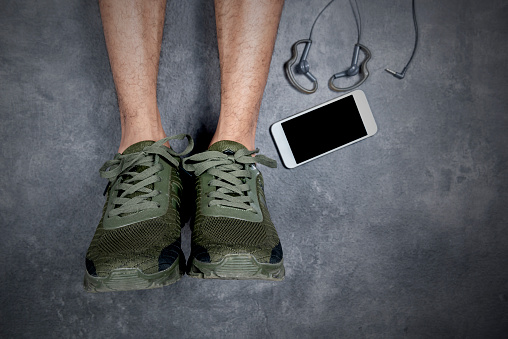 Man shoes with mobile phone and earphones with black background