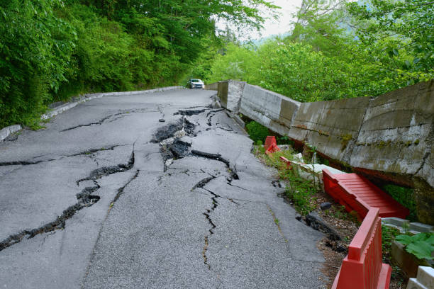 l'auto si sposta sul manto stradale distrutto. frana. - road street thoroughfare hole foto e immagini stock