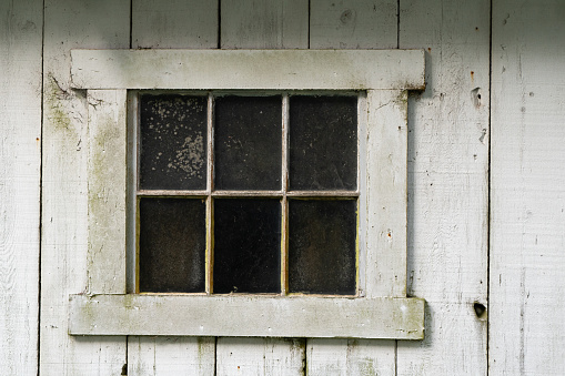 old antique window with weathered white wood boards