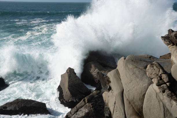 istock large ocean waves crashing over rock boulders 1398947189