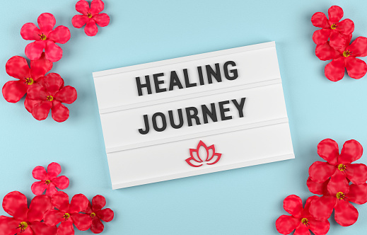 Healing Journey and lotus icon on Lightbox with red flowers. Wellness concept.