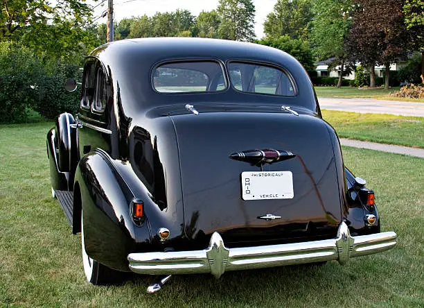 A rear side view of a black vintage Buick - Emblems removed - 1930's?
