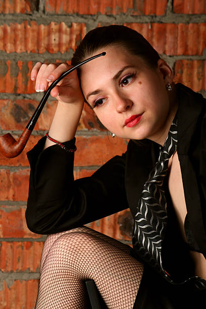 Girl in black suit with tobaco-pipe. stock photo