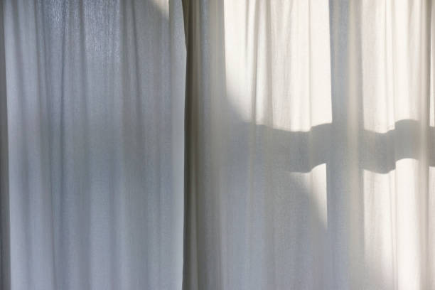 istock Morning sun shines through white curtains 1398950013