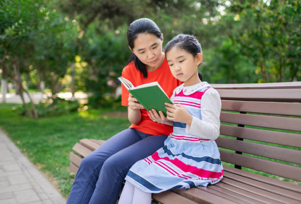 istock Little Girl and Mother Reading Book 1398950922