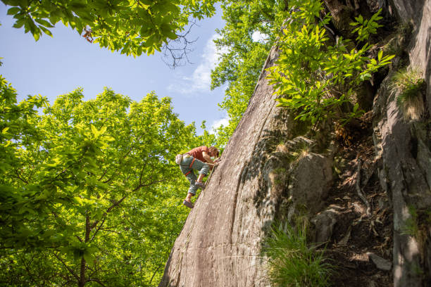 istock Young man climbing vertical rock face 1398952319