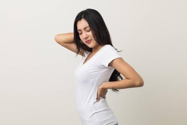 istock Asian woman has problem with structural posture She had neck and back pain. She massaged her neck and shoulders for relief. reduce muscle tension. Standing on isolated white background 1398952604