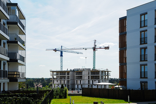 Grúa de construcción entre edificios de apartamentos en un soleado día de verano photo