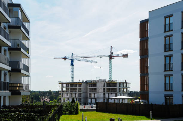 dźwig budowlany między budynkami mieszkalnymi w słoneczny letni dzień - blue construction construction site crane zdjęcia i obrazy z banku zdjęć