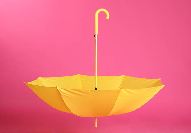 istock Stylish open yellow umbrella on pink background 1398954428