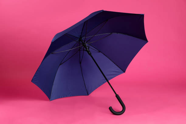 istock Stylish open blue umbrella on pink background 1398954689
