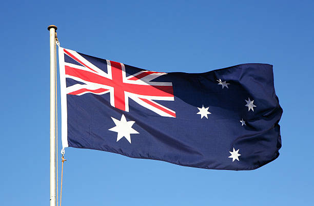 Waiving Australian flag on blue background stock photo