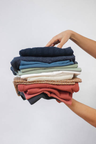 istock Woman holding clothes in hands. Stack of clothes 1398955233