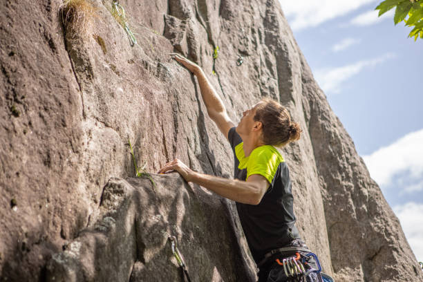 istock Man climbs steep rock face outdoors 1398955304