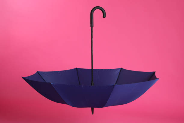 istock Stylish open blue umbrella on pink background 1398955351