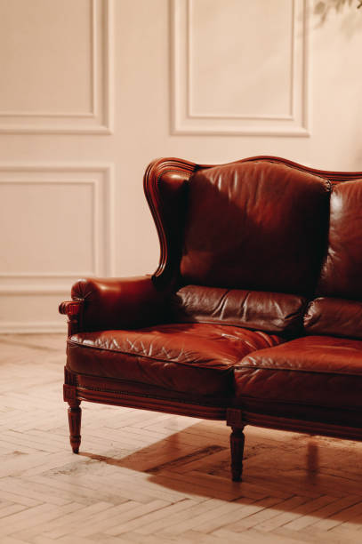 istock Vertical photo leather sofa, artificial light, antique furniture. Live white interior 1398955505