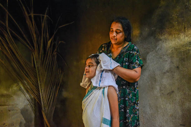 Indian mother drying 7 year old daughters hair at home, city girl enjoying rural life style