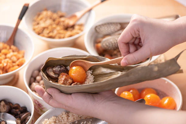 istock Making zongzi food - preparing and wrapping Chinese rice dumpling. 1398956926