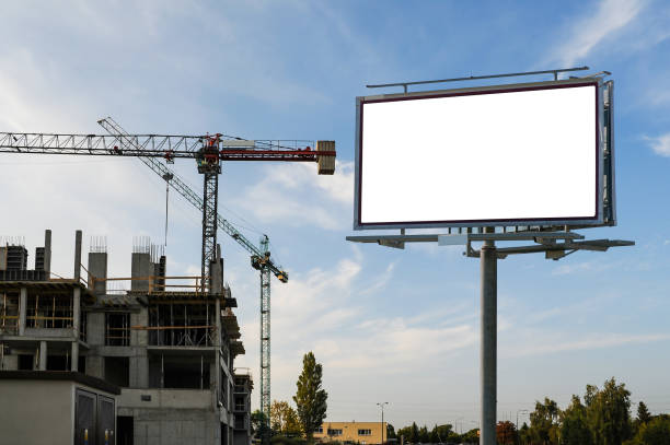 istock Blank white billboard mockup on the construction site with building cranes 1398962550