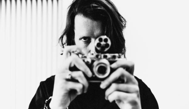 The fashion photographer. Portrait of a successful young Italian fashion photographer. He looks concentrated on his model. Full of passion and professionalism! black and white portrait photographers stock pictures, royalty-free photos & images