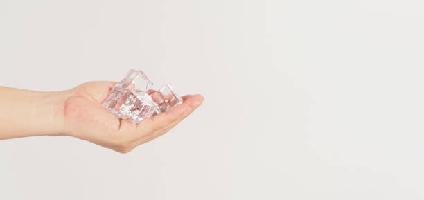 istock Hand is holding ice cubes on white background.