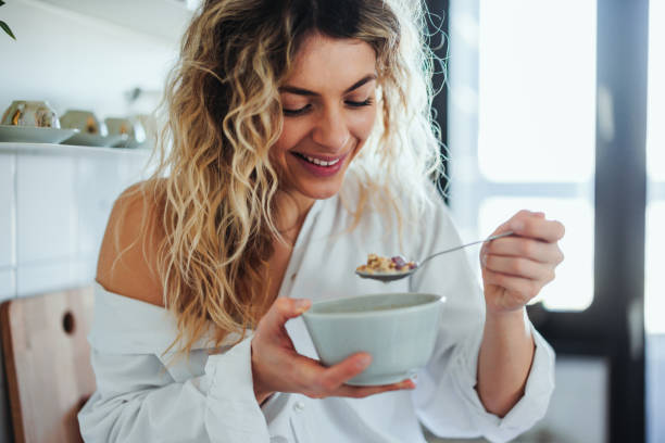 istock Young woman eating oatmeal 1398965573