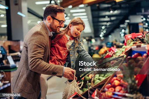 istock Father and daughter shopping in a grocery store 1398965606