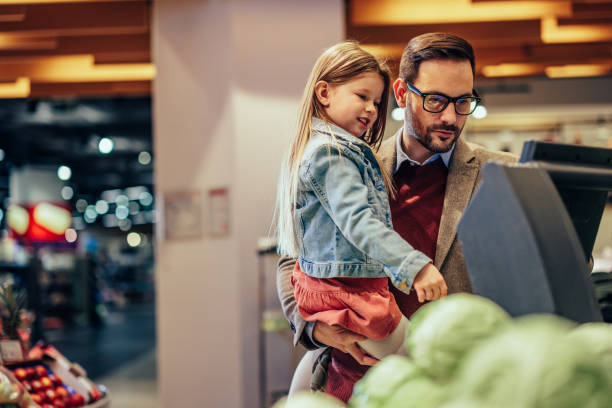 istock Father and daughter shopping in a grocery store 1398965629