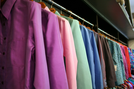 Rows of colored silk suits hanging on a shop rack