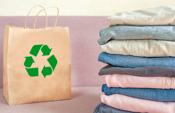 istock a stack of clothes and a bag with a recycle sign on a pink sofa 1398966046