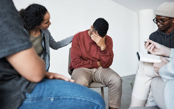 istock Man having a breakdown during group therapy session about addiction. Counsellor giving support to depressed crying african man at group psychological treatment 1398967642