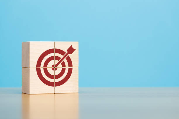 istock Wooden blocks with red target icon on wooden table blue background copy space. 1398967877