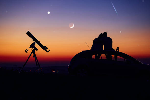 istock Couple stargazing together with a astronomical telescope. 1398968514