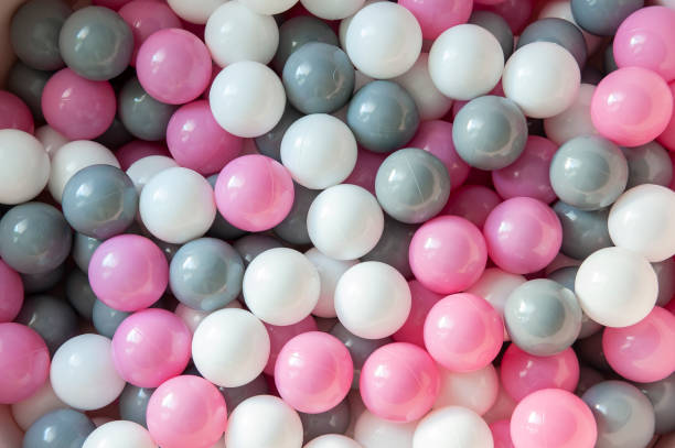 top view of pink, grey and white plastic balls in the pool. kids playground - ball pool imagens e fotografias de stock